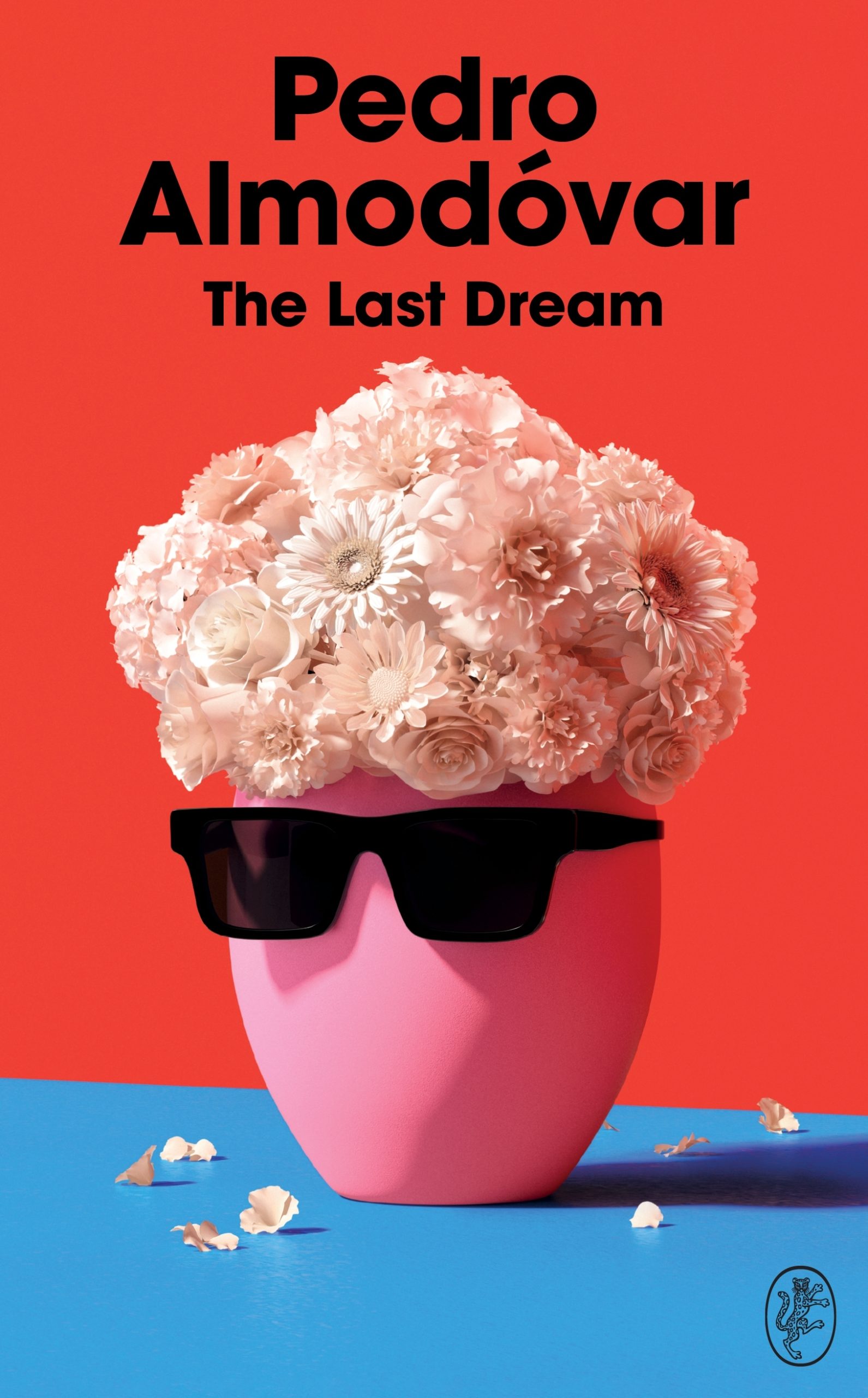 Book cover of THE LAST DREAM by Pedro Almodóvar, translated by Frank Wynne. The cover is a pink vase of flowers with a pair of black sunglassed, making it look like Almodóvar's trademark pompadour hair.